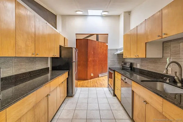 a kitchen with stainless steel appliances a sink stove and refrigerator