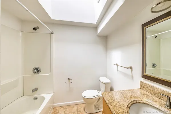 a bathroom with a granite countertop sink toilet and shower