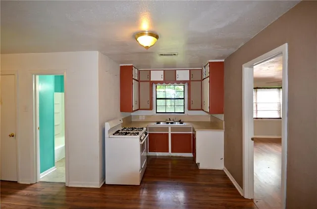 a view of a kitchen with a stove wooden floor and a window