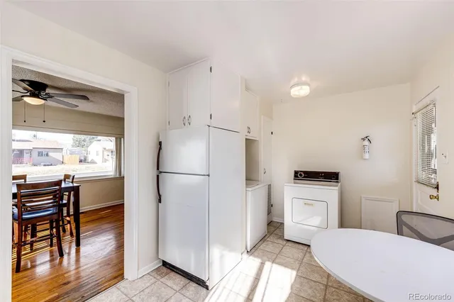 a bathroom with a toilet a sink and a refrigerator