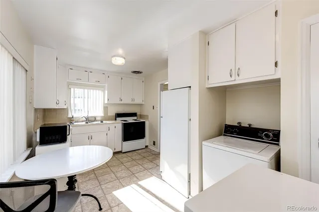 a kitchen with a refrigerator a stove a sink dishwasher and white cabinets with wooden floor