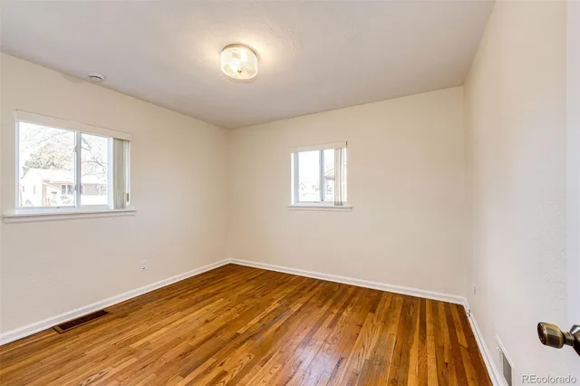 a view of empty room with wooden floor