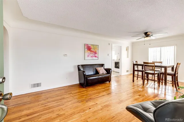 a living room with furniture and a wooden floor
