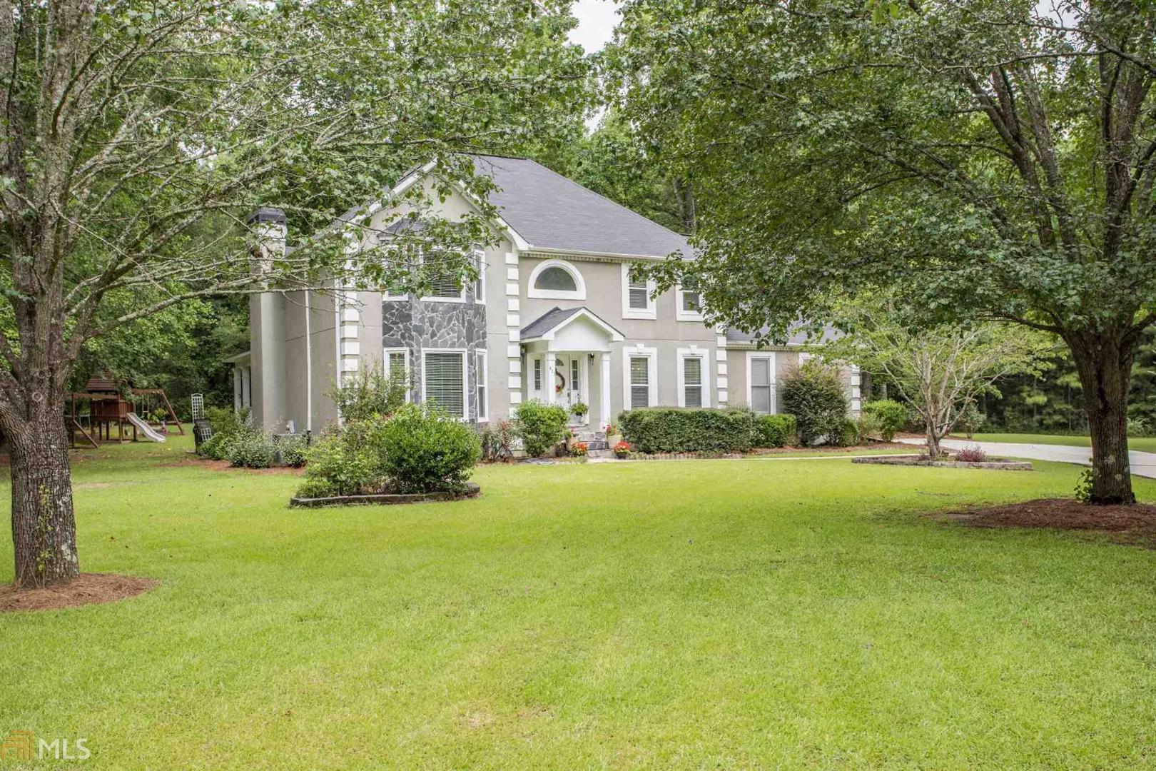 a front view of a house with yard and green space