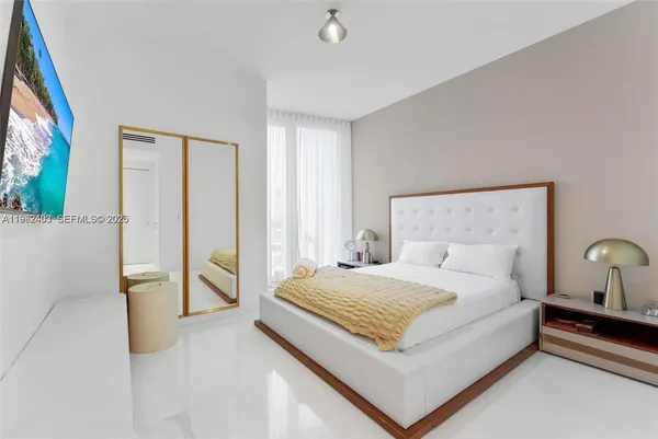 a large bed sitting in a bedroom next to a window