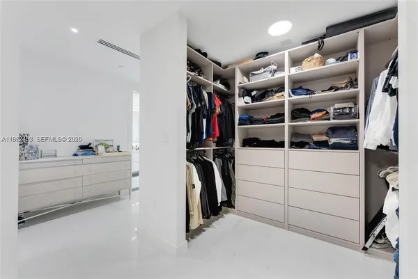 a view of walk in closet with clothes