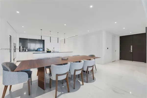 a kitchen with stainless steel appliances kitchen island granite countertop a dining table chairs and view kitchen