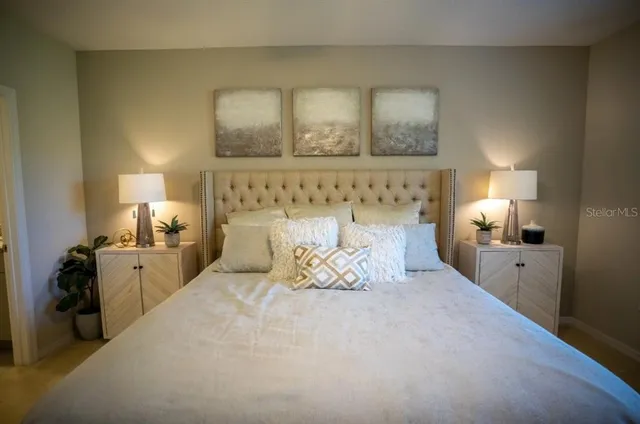 a bedroom with a bed and a lamp on dresser