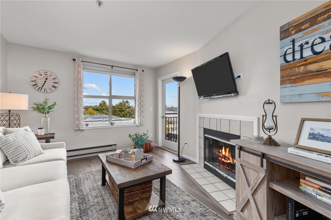 769 Hayes Street, Unit 609 Seattle, WA 98109 - Photo 2 of 26 a living room with furniture a flat screen tv and a fireplace