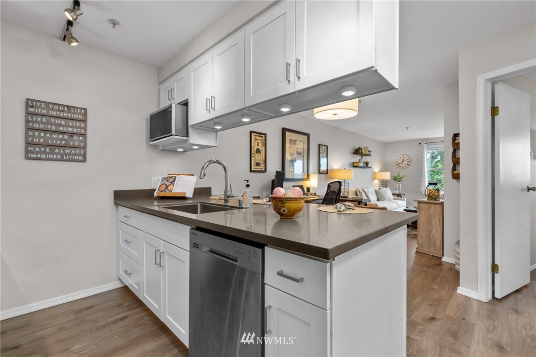 769 Hayes Street, Unit 609 Seattle, WA 98109 - Photo 11 of 26 a kitchen with stainless steel appliances granite countertop a sink stove and cabinets