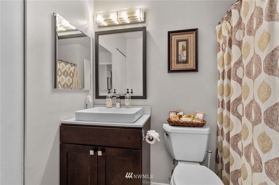 769 Hayes Street, Unit 609 Seattle, WA 98109 - Photo 15 of 26 a bathroom with a toilet sink and mirror