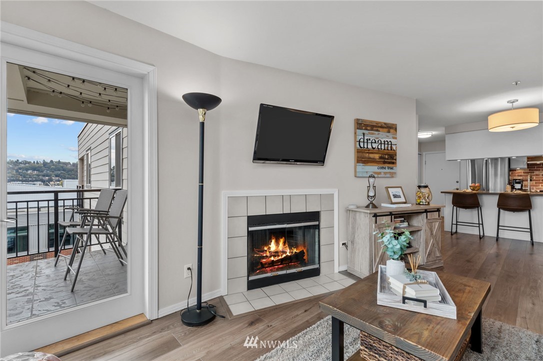 769 Hayes Street, Unit 609 Seattle, WA 98109 - Photo 5 of 26 a living room with furniture a fireplace and a flat screen tv
