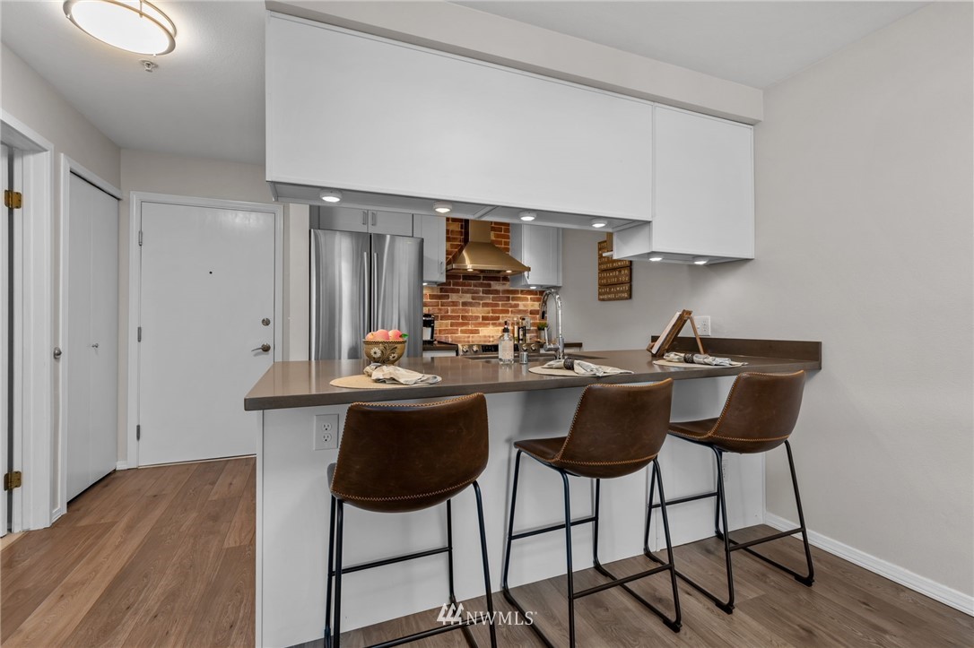 769 Hayes Street, Unit 609 Seattle, WA 98109 - Photo 9 of 26 a kitchen with stainless steel appliances a sink and cabinets