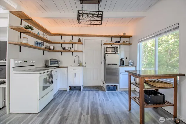 a kitchen with white cabinets and appliances