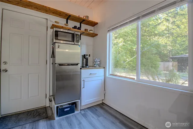 a kitchen with cabinets wooden floor and stainless steel appliances