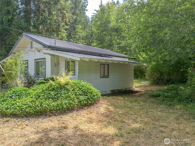 a front view of house with yard and trees around
