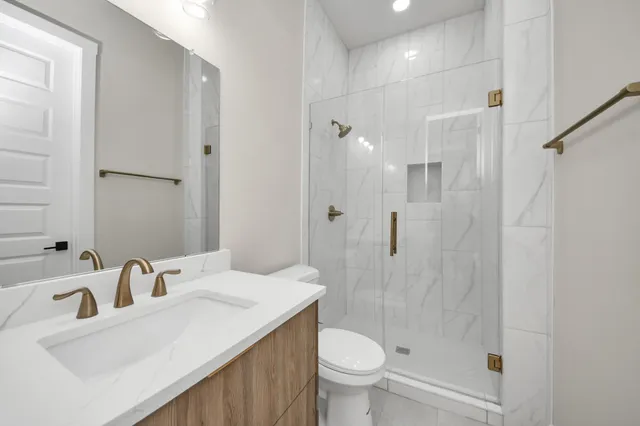 a bathroom with a sink toilet a mirror and shower