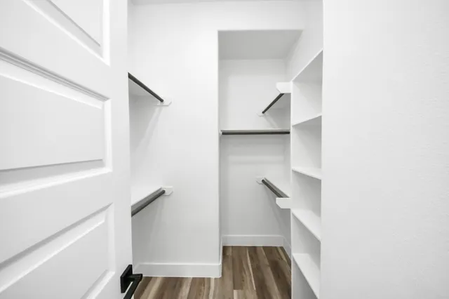 a view of walk in closet with empty racks
