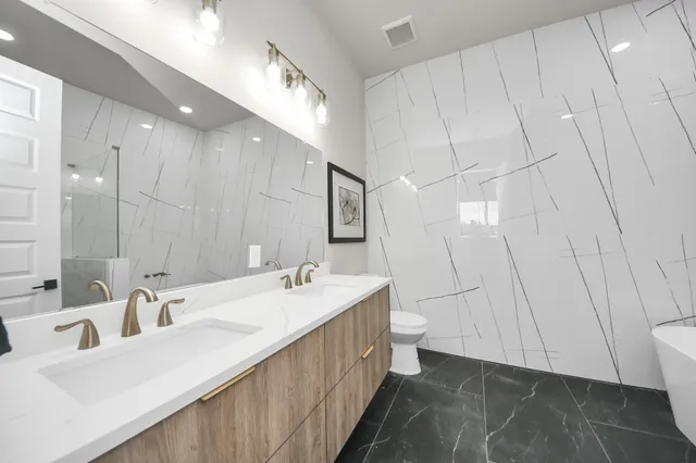 a bathroom with double vanity and a mirror