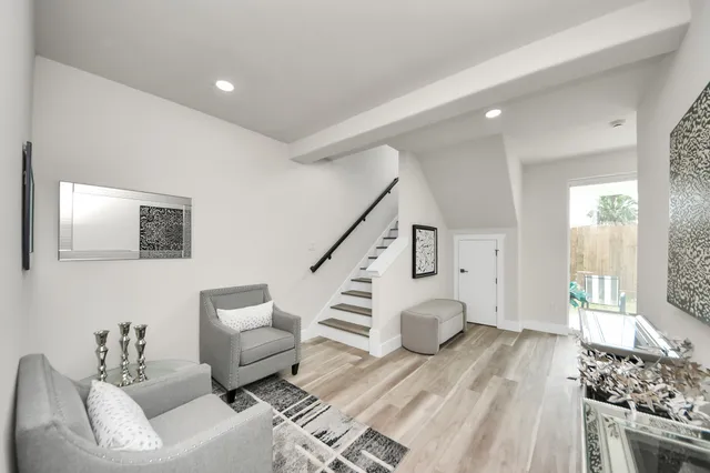 a living room with furniture and a wooden floor