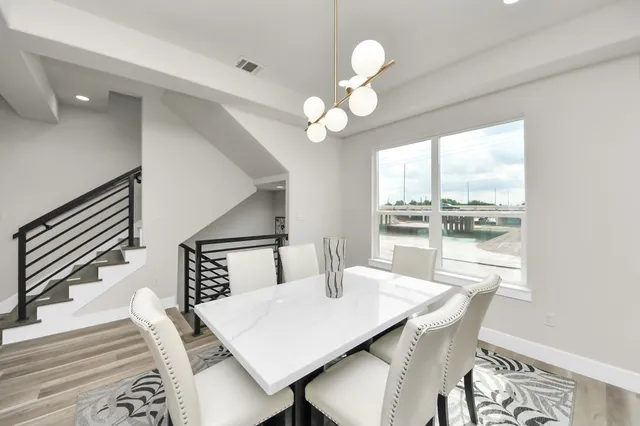 a view of a dining room with furniture a chandelier and wooden floor