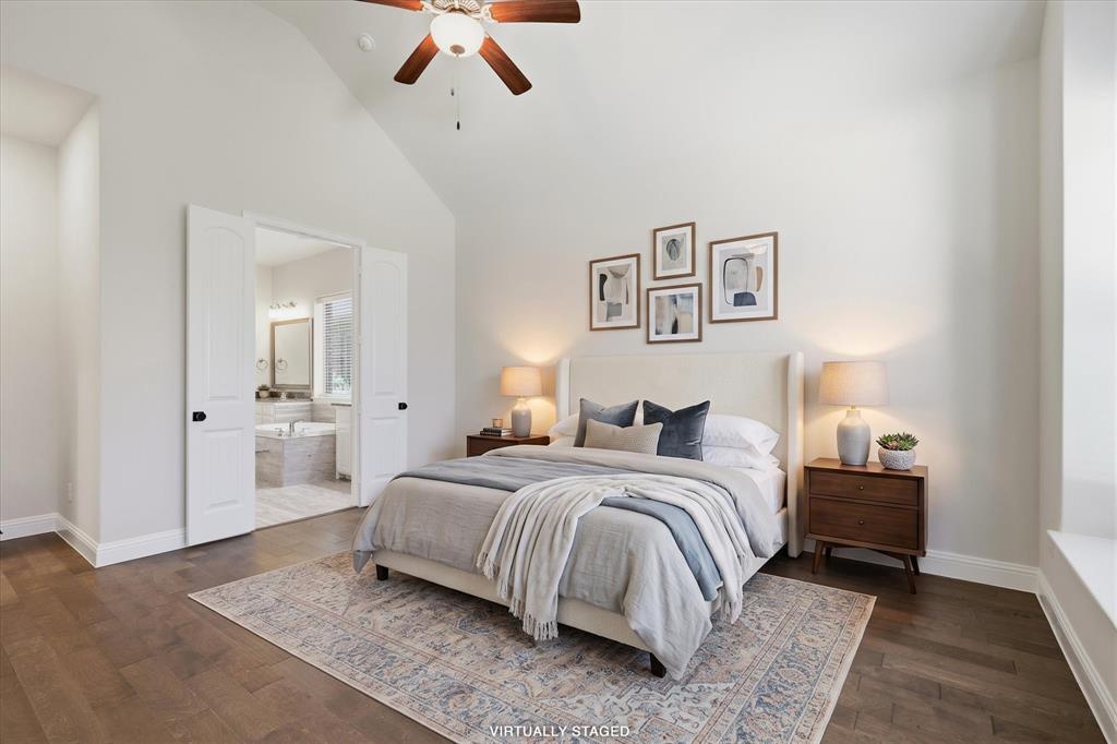 2433 Mare Road Carrollton, TX 75010 - Photo 3 of 37 Primary bedroom suite featuring a vaulted ceiling with ceiling fan, wood flooring, and an ensuite bathroom accessible through French doors