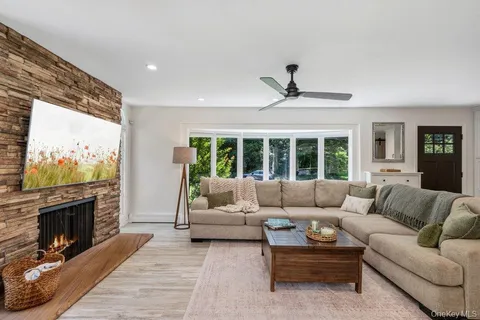 a living room with furniture a large window and a flat screen tv
