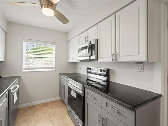 a kitchen with granite countertop a stove and a microwave