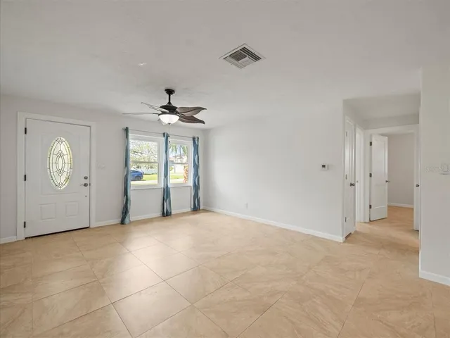 an empty room with fan and windows