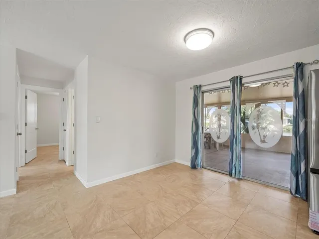 a view of a kitchen with refrigerator and wooden floor