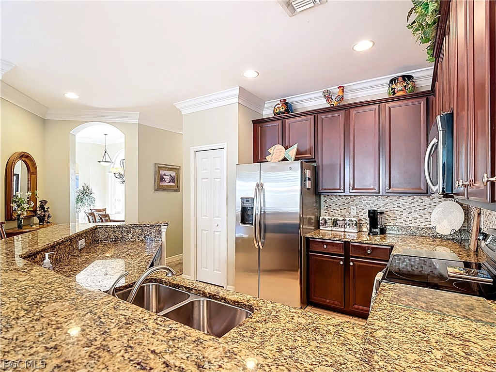 20763 Athenian Lane North Fort Myers, FL 33917 - Photo 11 of 49 a kitchen with granite countertop a sink stove and refrigerator