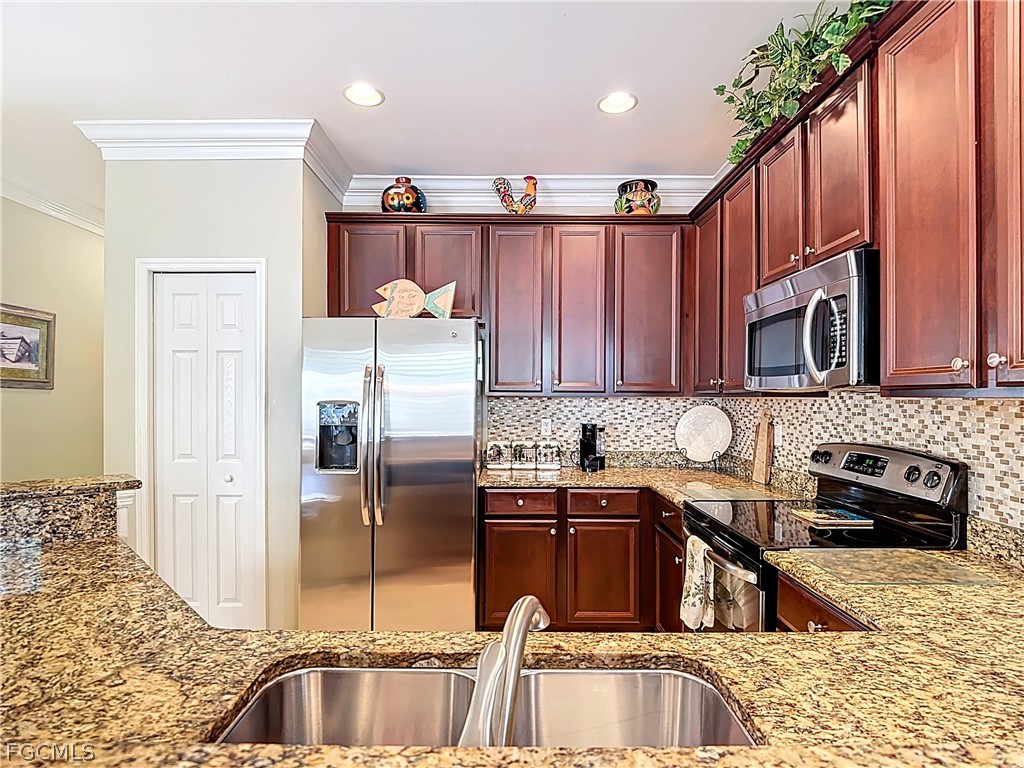 20763 Athenian Lane North Fort Myers, FL 33917 - Photo 12 of 49 a kitchen with stainless steel appliances granite countertop a sink refrigerator and cabinets