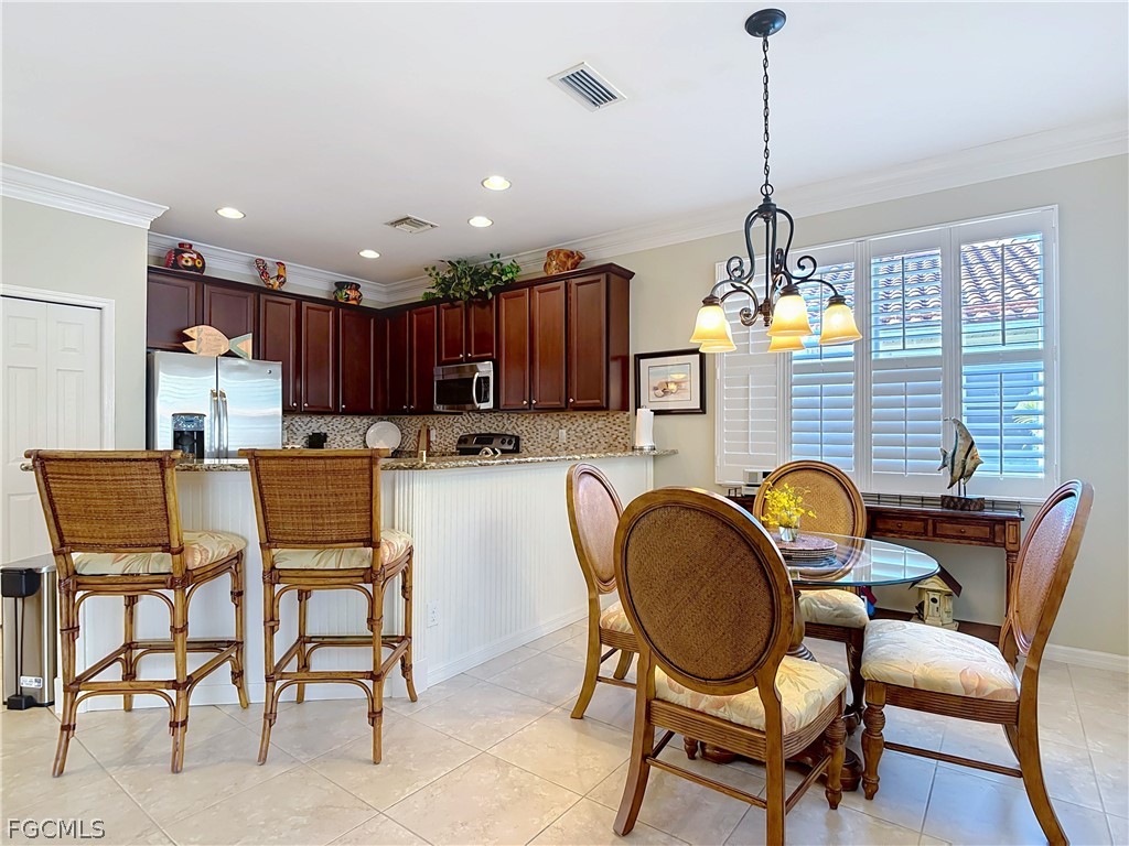 20763 Athenian Lane North Fort Myers, FL 33917 - Photo 13 of 49 a dining room with furniture a chandelier and wooden floor