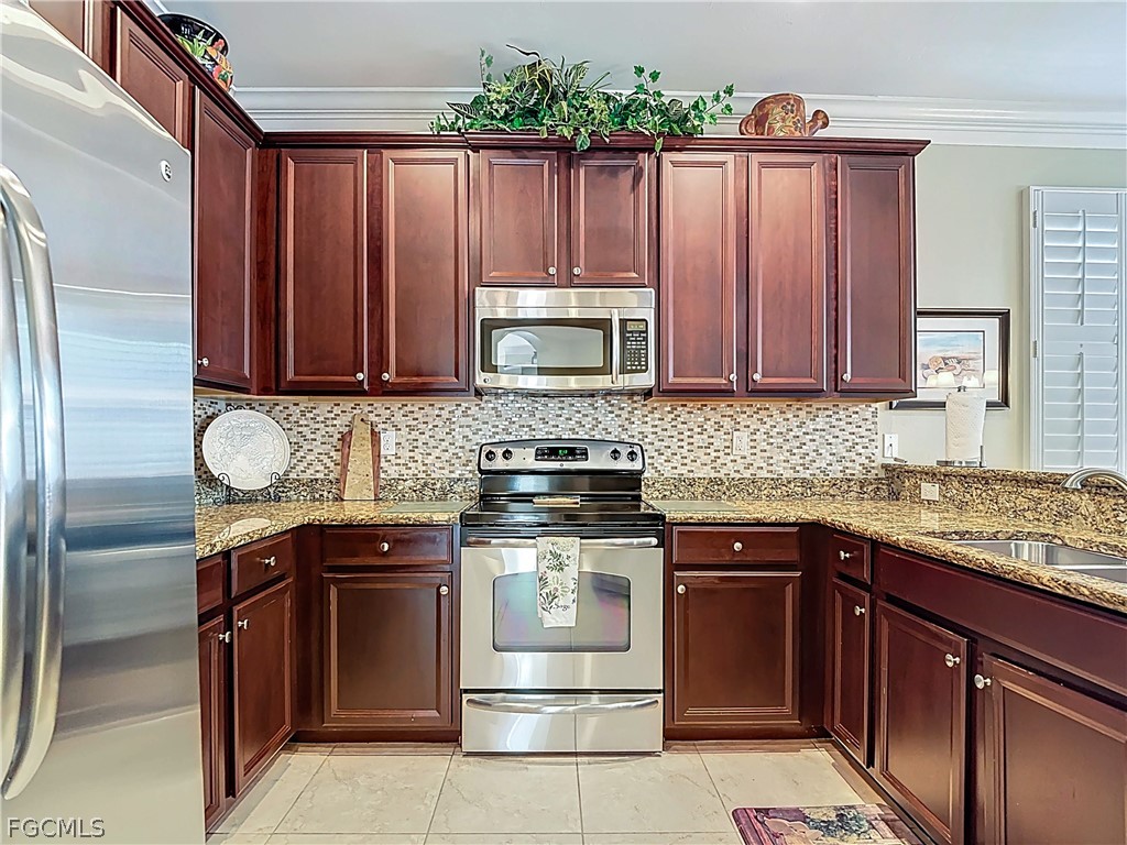 20763 Athenian Lane North Fort Myers, FL 33917 - Photo 9 of 49 a kitchen with granite countertop wooden cabinets stainless steel appliances and a sink