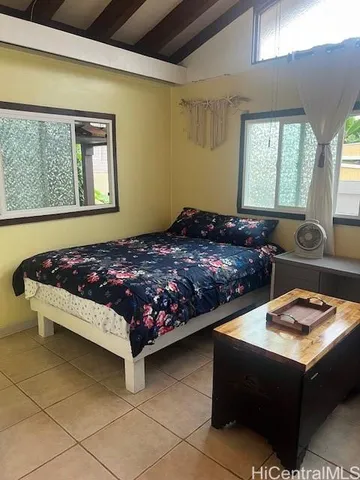 a bed sitting in a bedroom next to a window