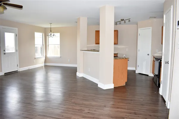a view of a kitchen with wooden floor and a refrigerator