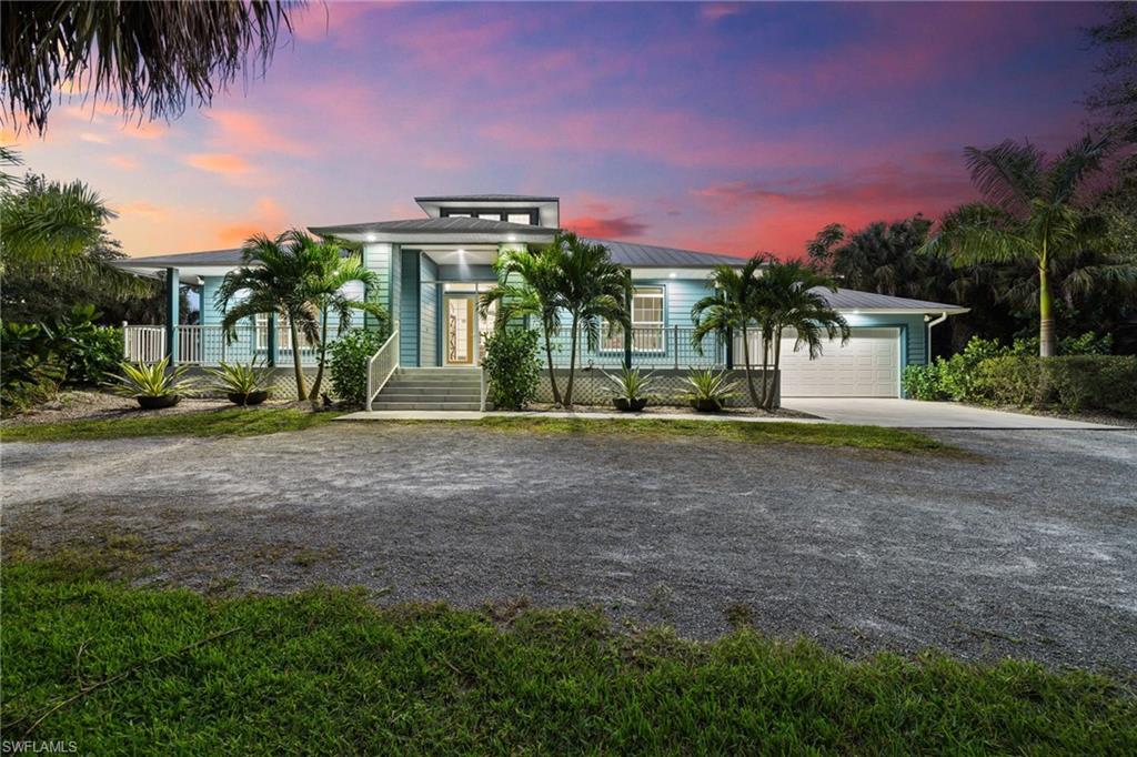 911 Mingo Drive Naples, FL 34120 - Photo 1 of 50 a front view of a house with a yard and a garage