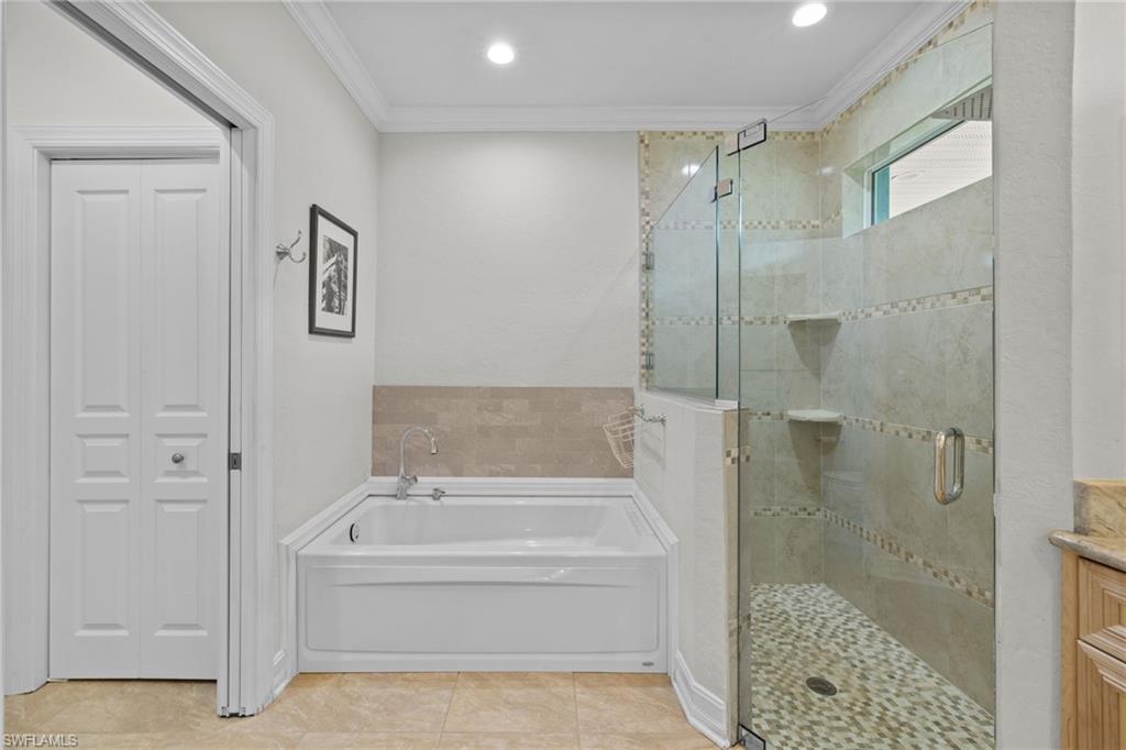 911 Mingo Drive Naples, FL 34120 - Photo 15 of 50 a bathroom with a bathtub and a shower