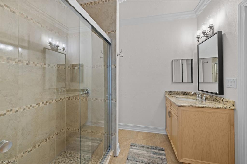 911 Mingo Drive Naples, FL 34120 - Photo 17 of 50 a bathroom with a granite countertop sink a mirror and shower