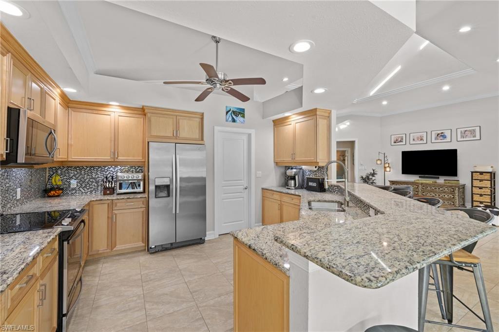 911 Mingo Drive Naples, FL 34120 - Photo 20 of 50 a kitchen with stainless steel appliances granite countertop a sink refrigerator and cabinets