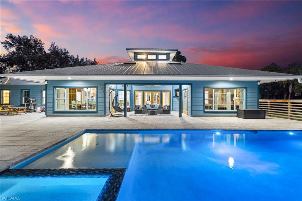 911 Mingo Drive Naples, FL 34120 - Photo 2 of 50 a view of a house with swimming pool and sitting area