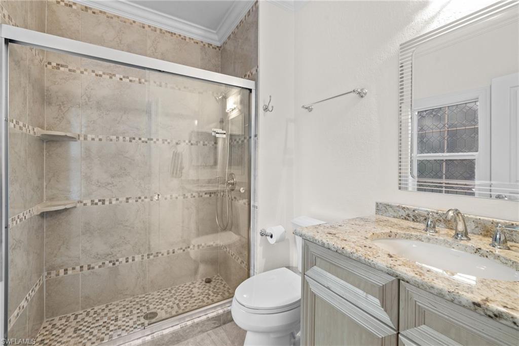 911 Mingo Drive Naples, FL 34120 - Photo 23 of 50 a bathroom with a granite countertop sink a toilet and shower