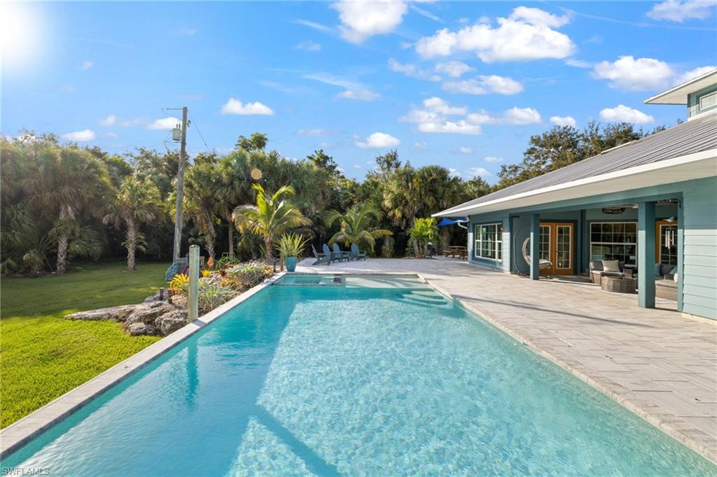911 Mingo Drive Naples, FL 34120 - Photo 26 of 50 a view of a house with swimming pool and a yard