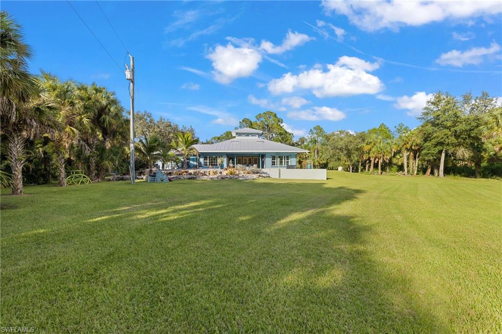 911 Mingo Drive Naples, FL 34120 - Photo 29 of 50 a front view of a house with a big yard