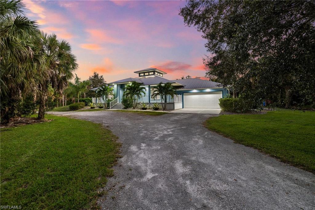 911 Mingo Drive Naples, FL 34120 - Photo 35 of 50 a front view of a house with a yard and tree s