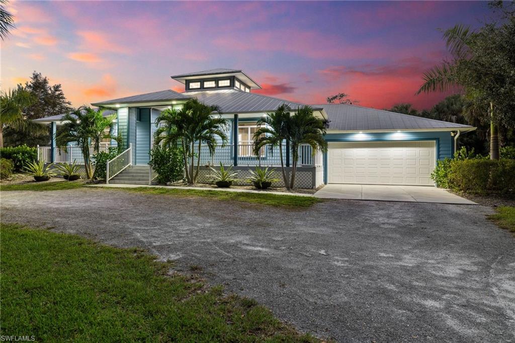 911 Mingo Drive Naples, FL 34120 - Photo 36 of 50 a front view of a house with a yard and garage
