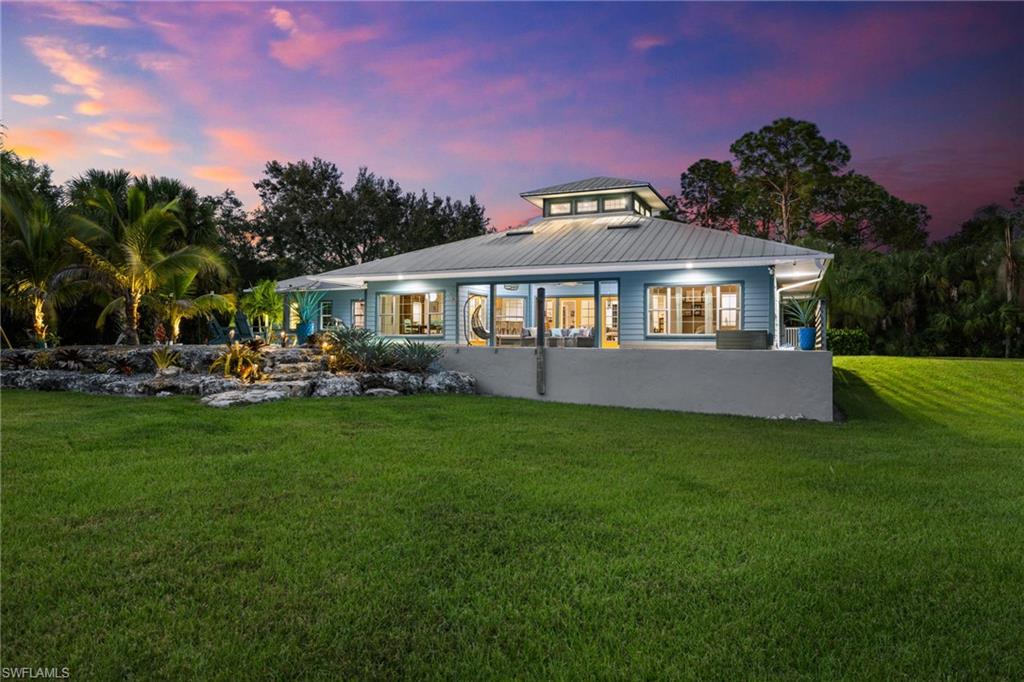 911 Mingo Drive Naples, FL 34120 - Photo 37 of 50 a front view of a house with a garden and yard