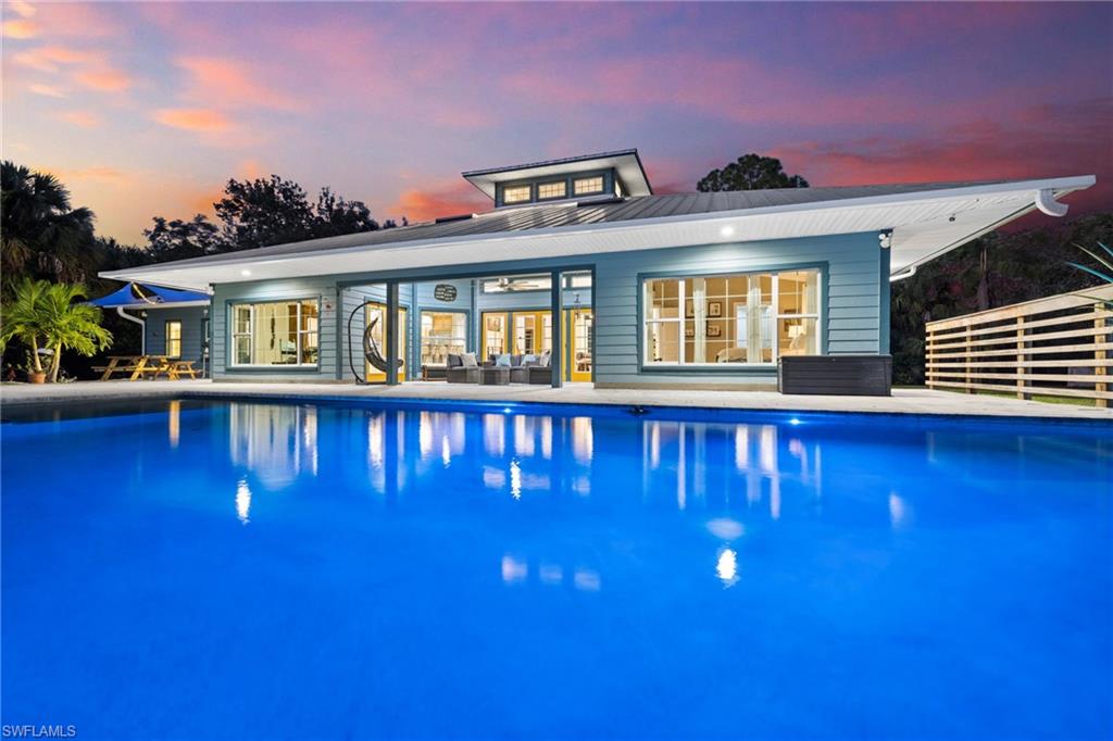 911 Mingo Drive Naples, FL 34120 - Photo 38 of 50 a front view of a house with swimming pool having outdoor seating