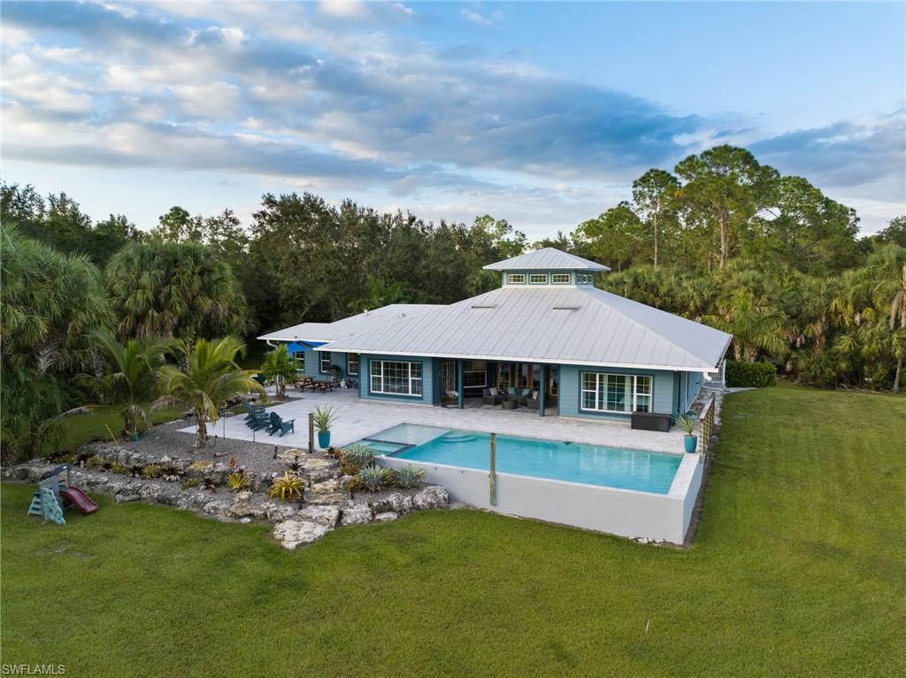 911 Mingo Drive Naples, FL 34120 - Photo 41 of 50 a view of a patio with table and chairs under an umbrella