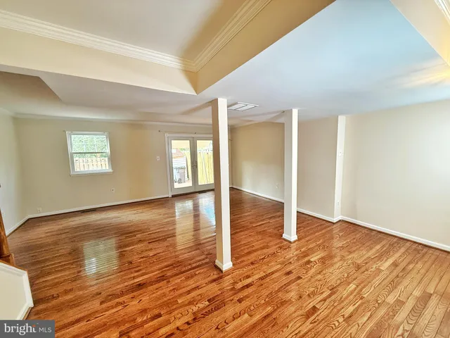 a view of empty room with wooden floor